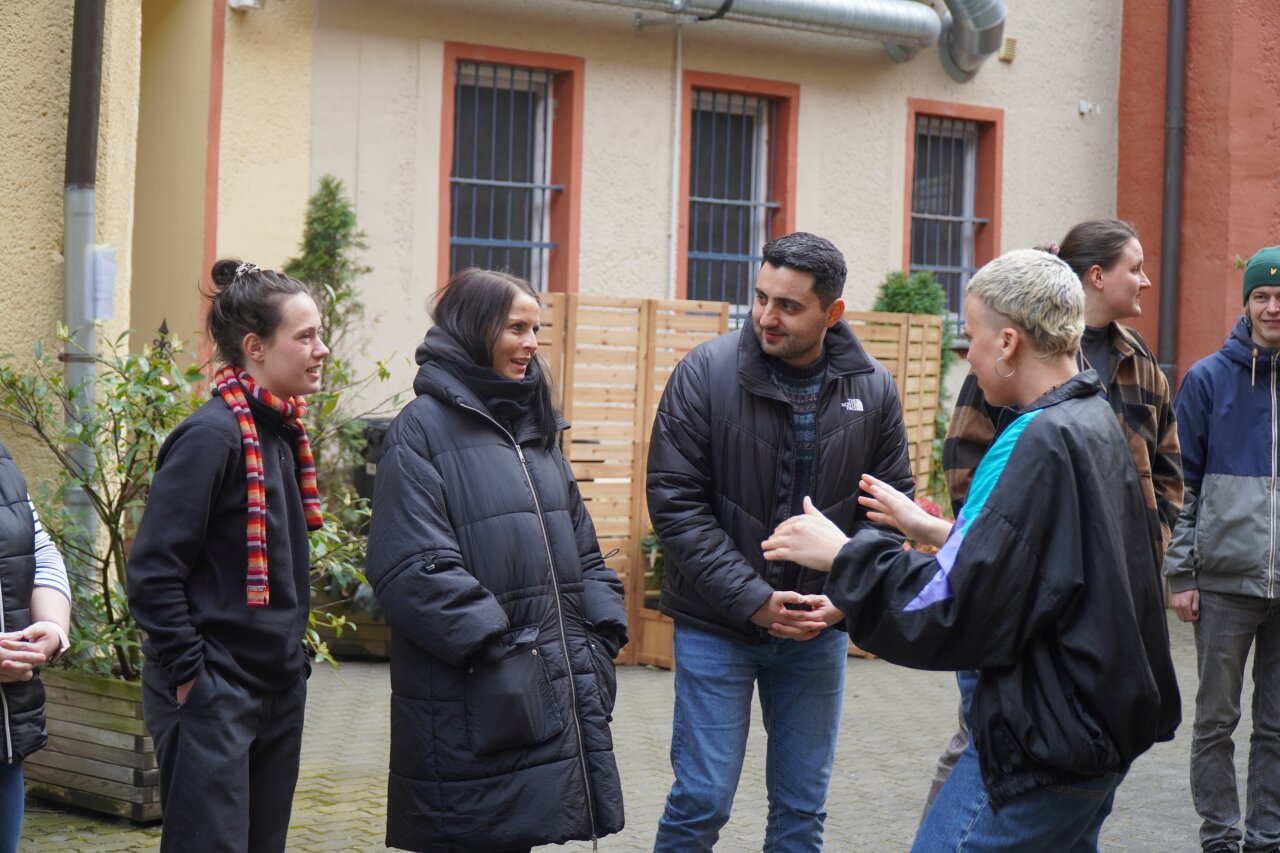 Eine Gruppe steht im Hof und macht ein Warm Up.