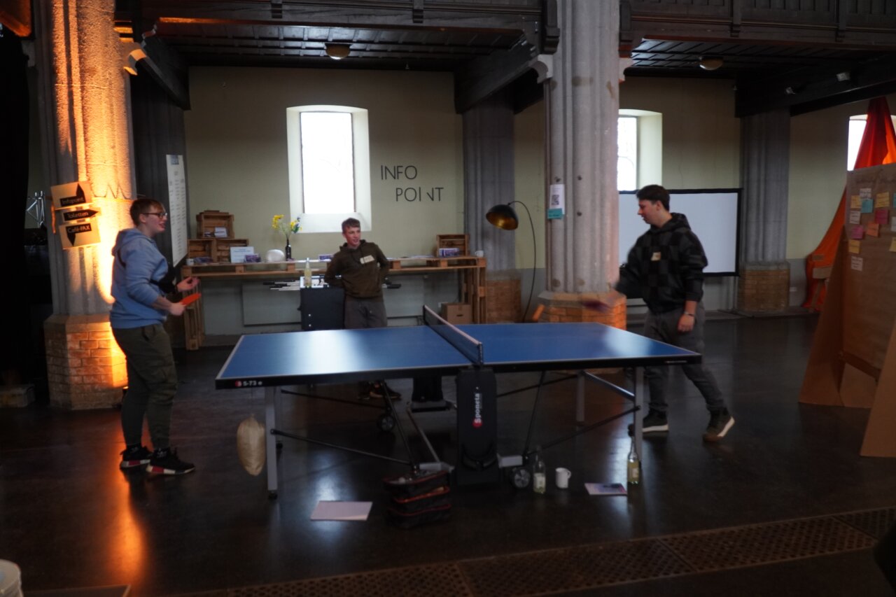 Zwei junge Menschen spielen Tischtennis miteinander.